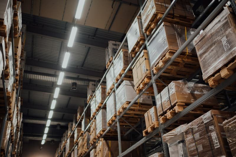 Dimly lit warehouse racking stacked with palletised goods at night