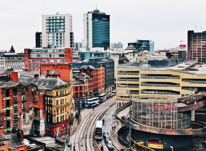 Aerial view over Manchester rooftops, red brick and modern towers