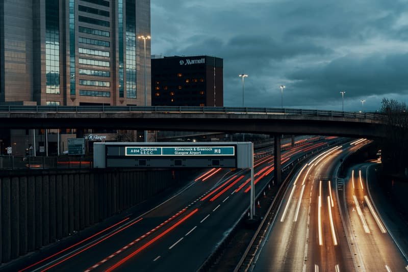 Elevated UK motorway at dusk with traffic heading out of the city
